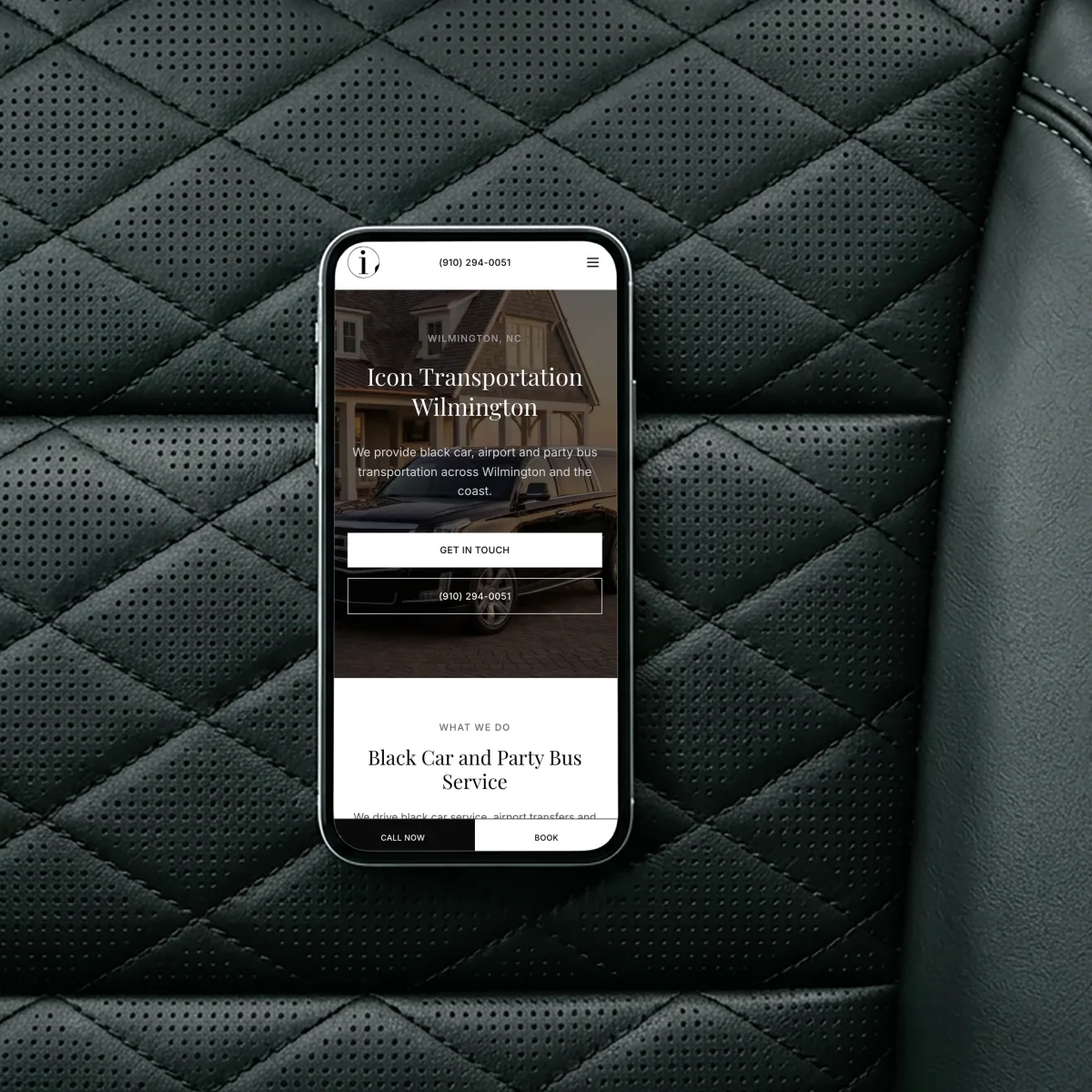 Icon Transportation Wilmington website on a phone, resting on the quilted leather seat of a black car