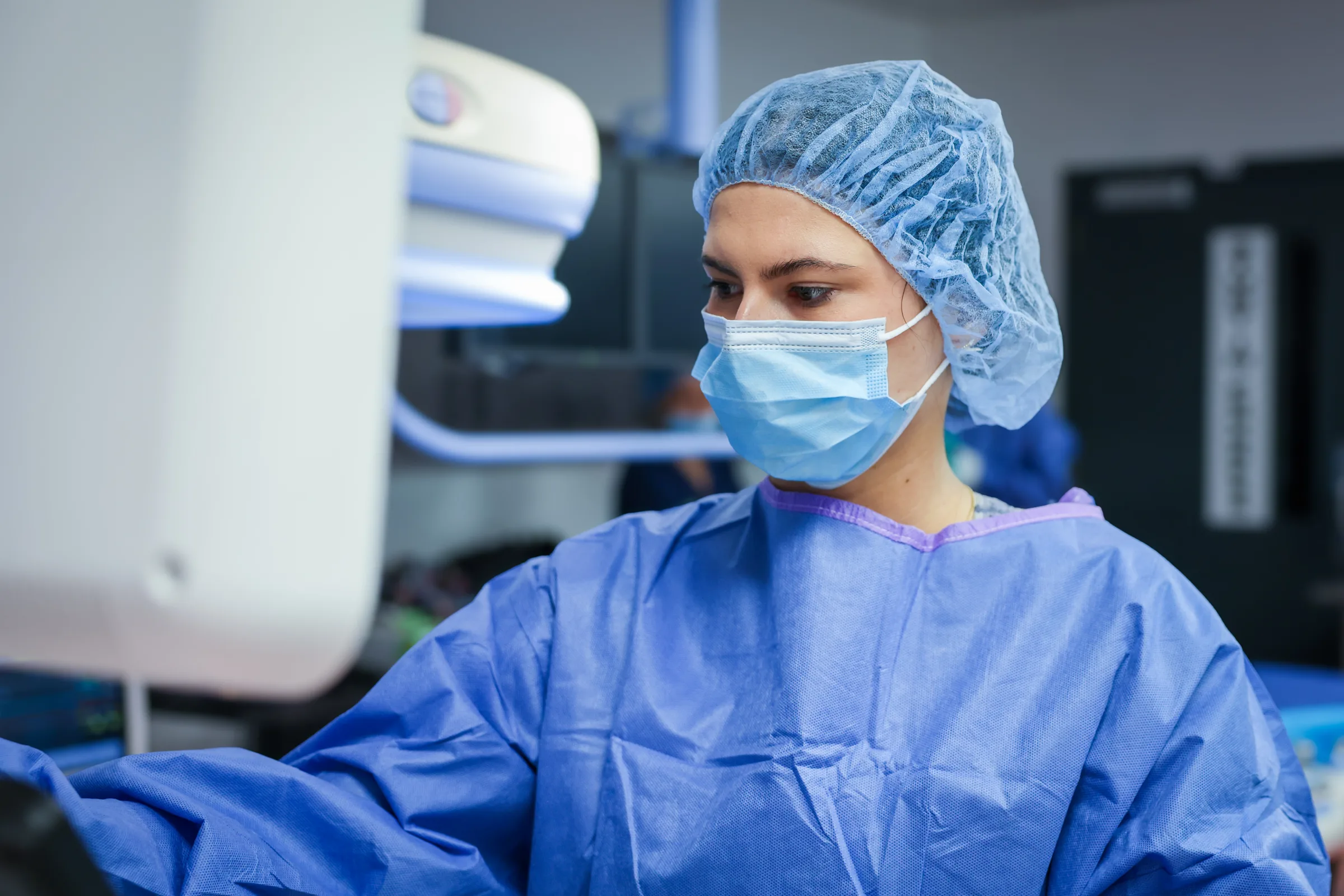 A gowned Synchrony Labs clinician watching an imaging monitor during a study