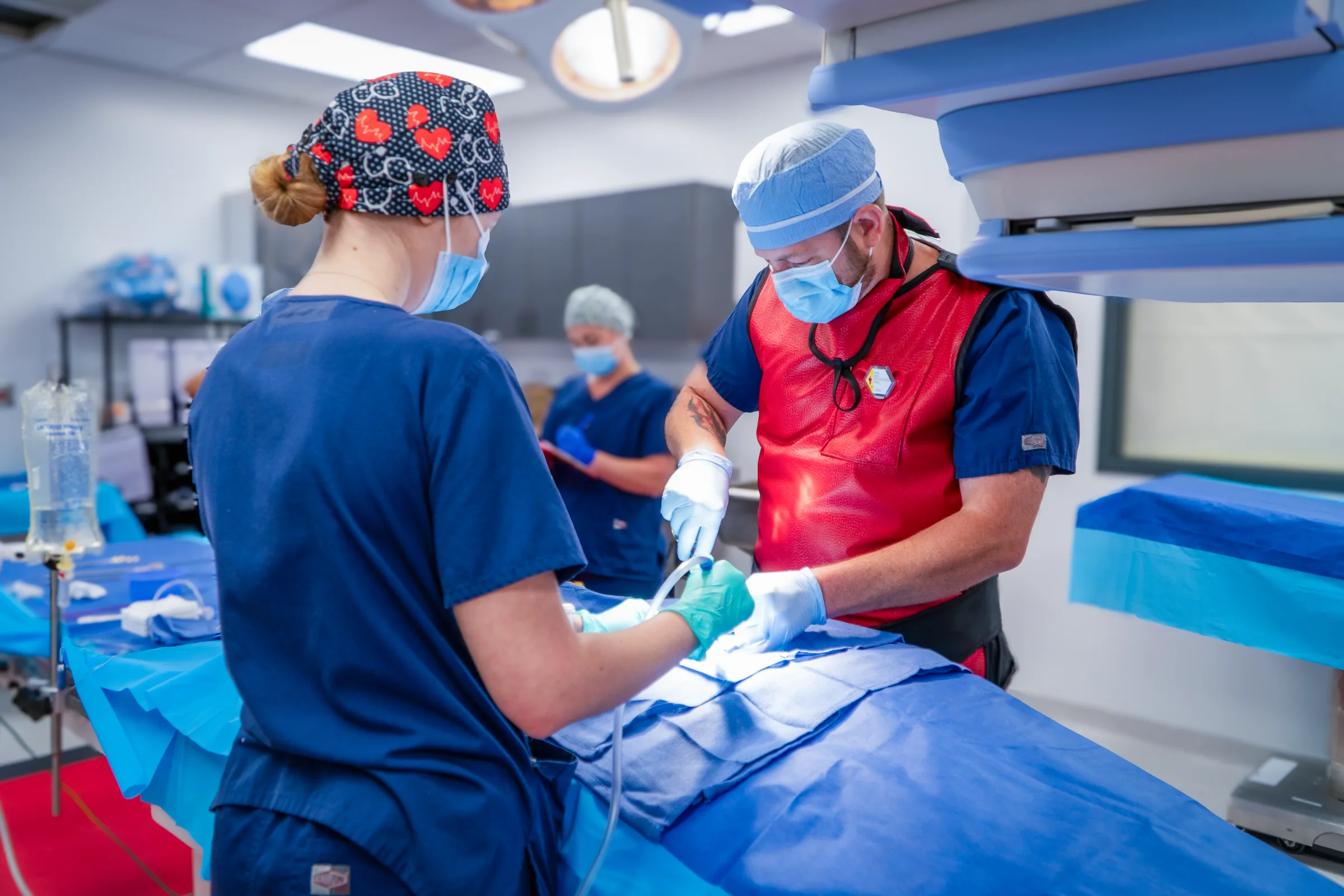 The Synchrony Labs team at the table during a cardiovascular procedure, one clinician in a lead apron